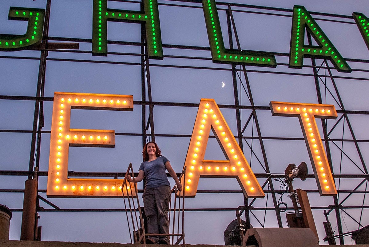 Photo of Nicole Possert with a neon sign