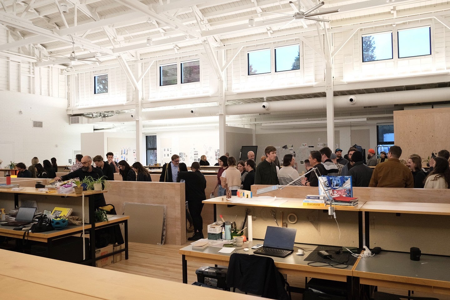 Shot of a crowd of students and professionals conversing in Highland Hall. 