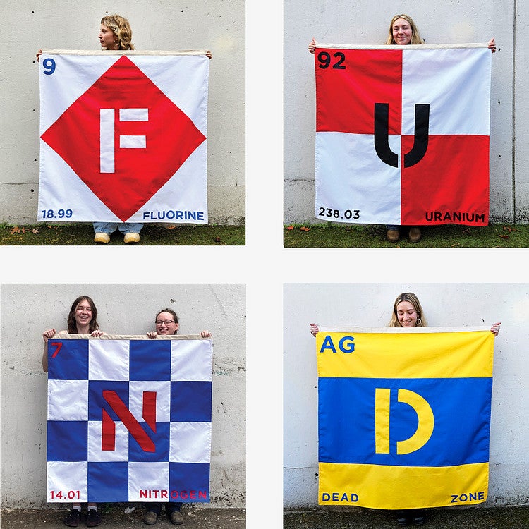 Photograph of four students holding up a coterie of different designed flags. 