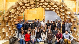Students posing in front of arch