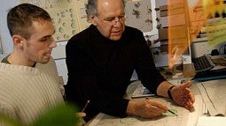 Photo of Otto Poticha with a student at a desk