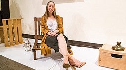 Student Stella Mae Christ sitting in a wooden chair