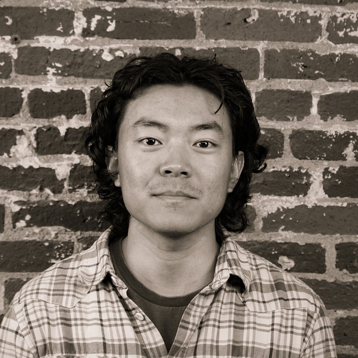 Photograph of a smiling first-year SPD student, Yuxin Mao, in front of a brick wall.
