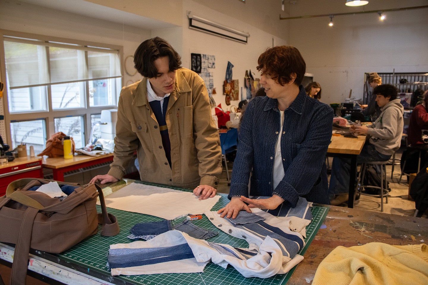 Two students talk about fibers project in fibers studio. Decorative. 