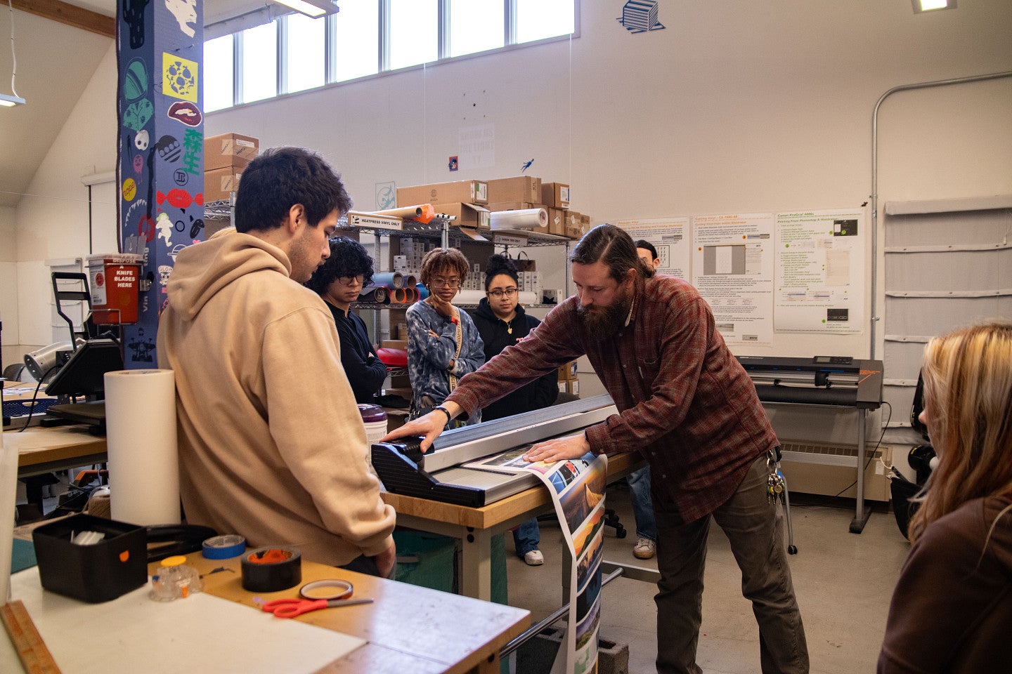Faculty member helps students with printer. Decorative. 