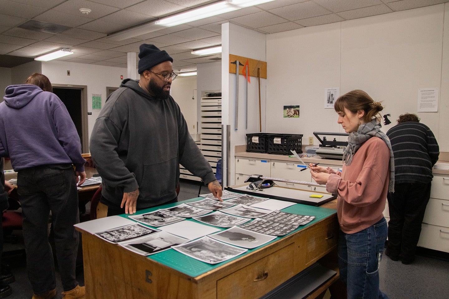 Photography faculty talks with students about their work in studio. Decorative. 