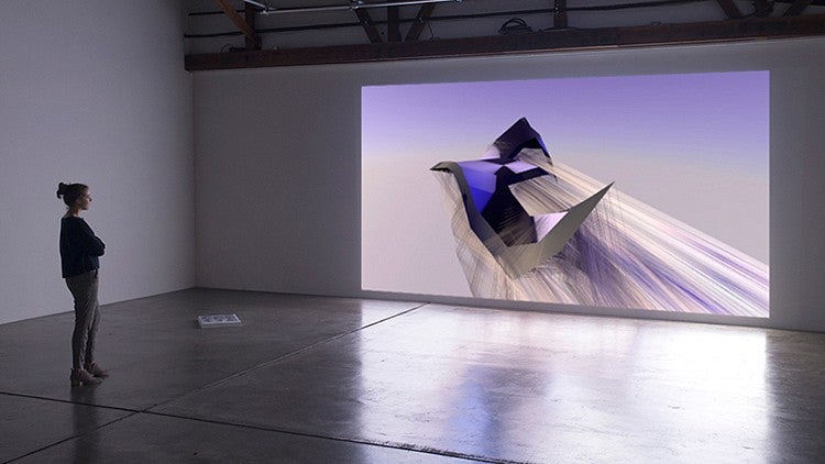 person looks at image projected on wall