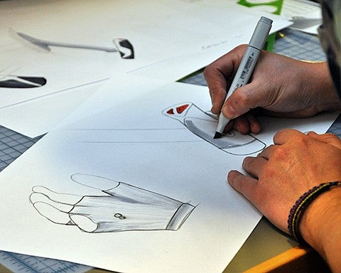 student adds color to drawing of glove deisgn