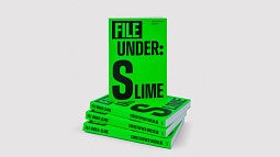 Photo is of the book, "File Under:  Slime", positioned upright on a stack of additional copies of the same book. Book is bright green with the title in simple, black font.