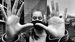 Black and white photo of woman holding up a mirror