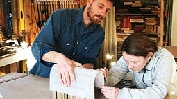 Photo of a mentor and student working at a draft table