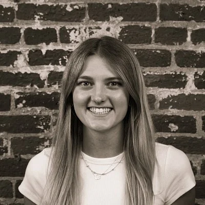 Photograph of a smiling first-year SPD student, Makena Klatt, in front of a brick wall.