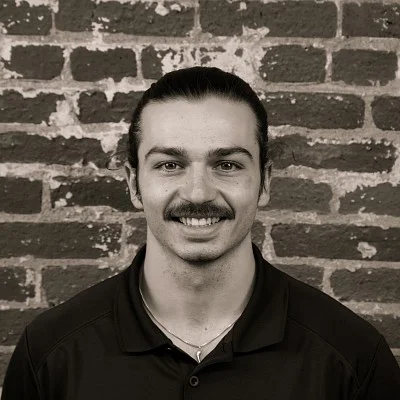 Photograph of a smiling first-year SPD student, Vic Edwards, in front of a brick wall.