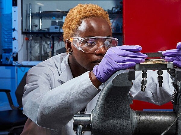 A researcher examines a laboratory instrument.