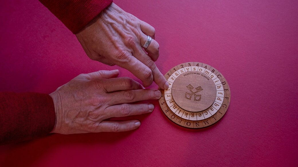 Corinne Bayerl turns a wooden cipher wheel.