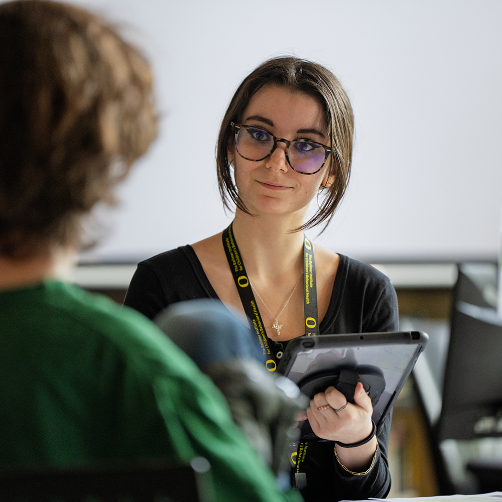 Ballmer student talks to a teenager in a classroom.
