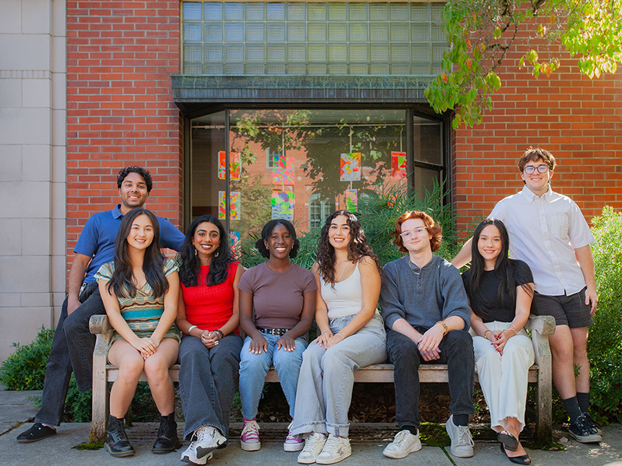 A group of students smiling on a bench