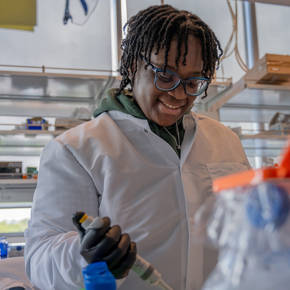 student at lab bench pipetting