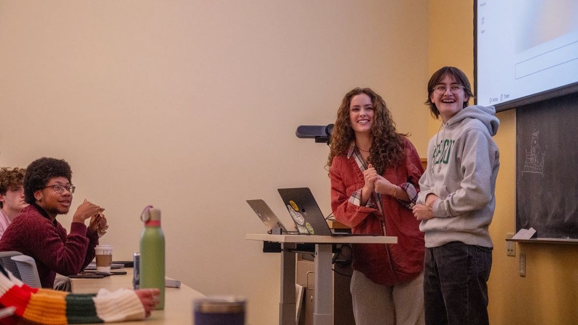 Two students presenting in front of a classroom