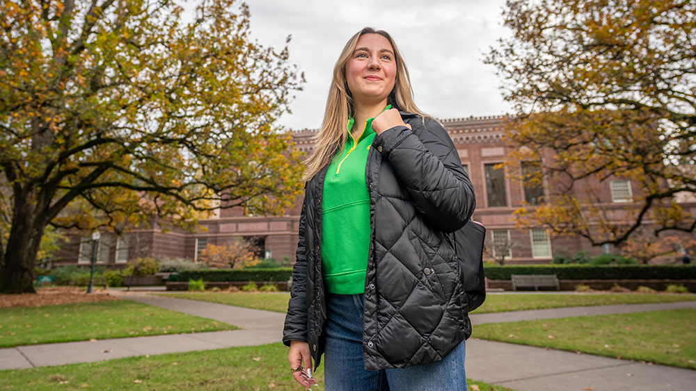 A student standing outside in the UO's memorial quad