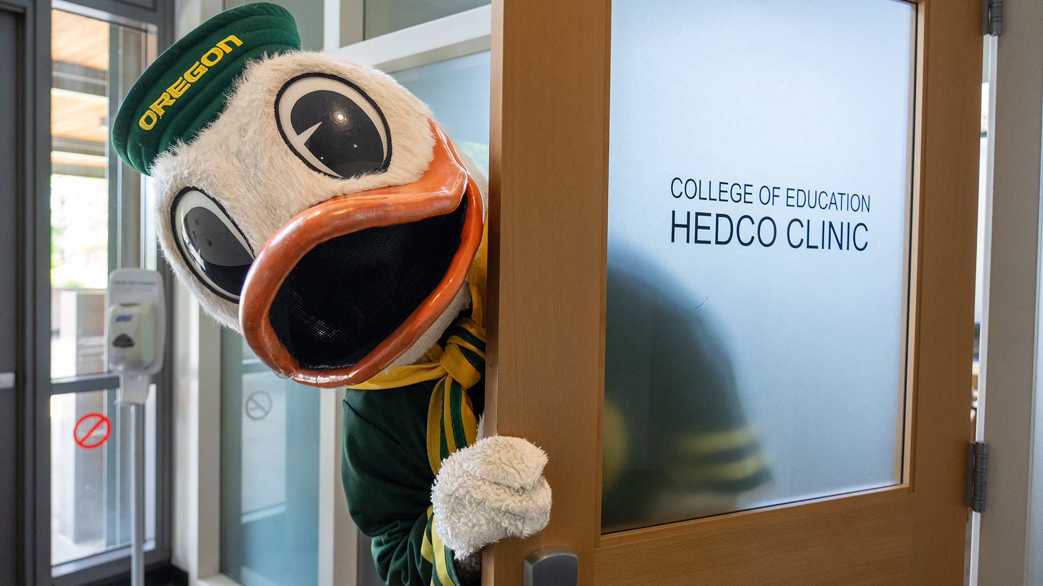 The Duck mascot peeks around a HEDCO Clinic door.
