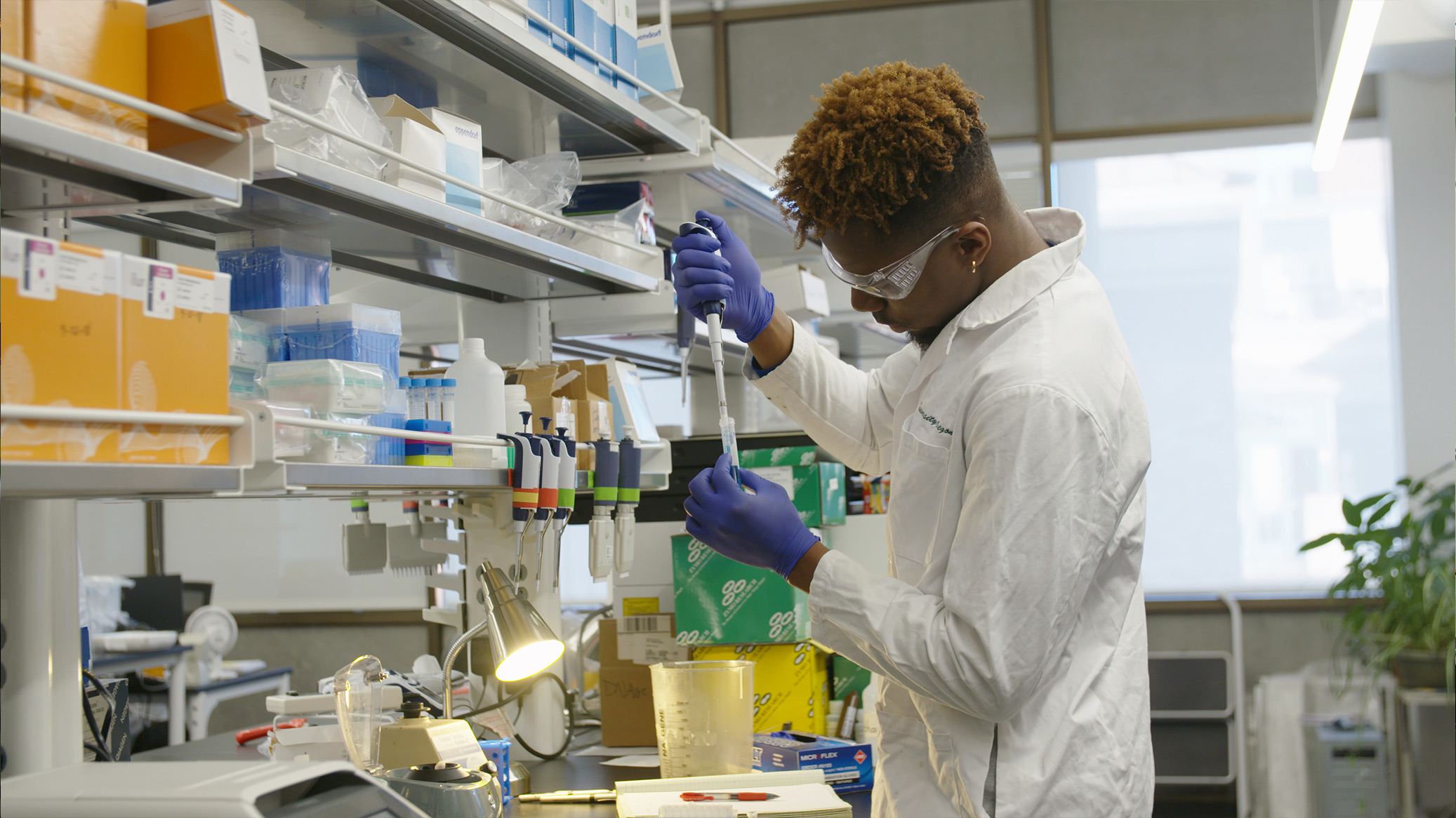 A researcher pipetting a sample at a lab bench