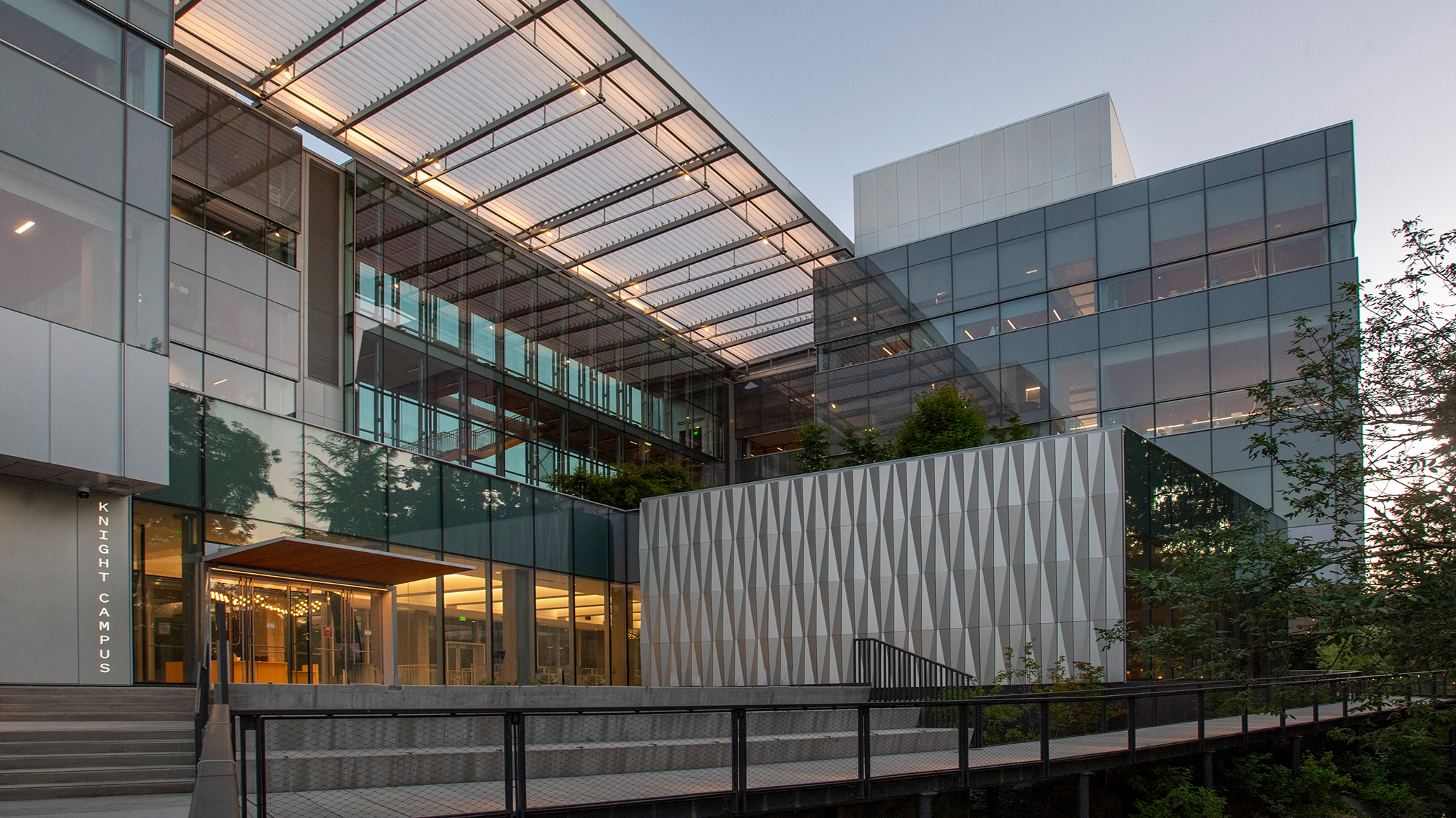 The Knight Campus entrance and glass buildings at dusk