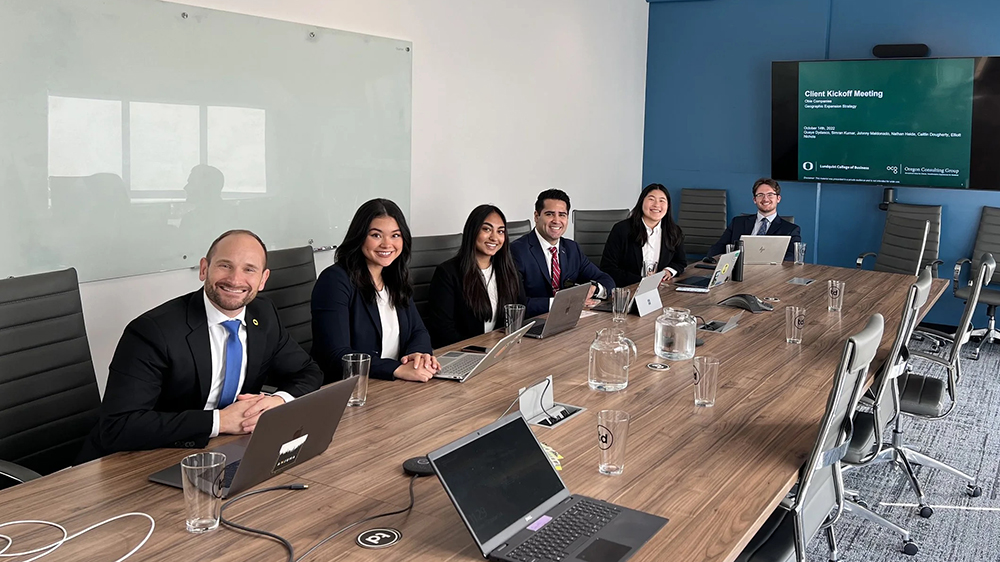 Students and faculty sitting around a table in a conference room
