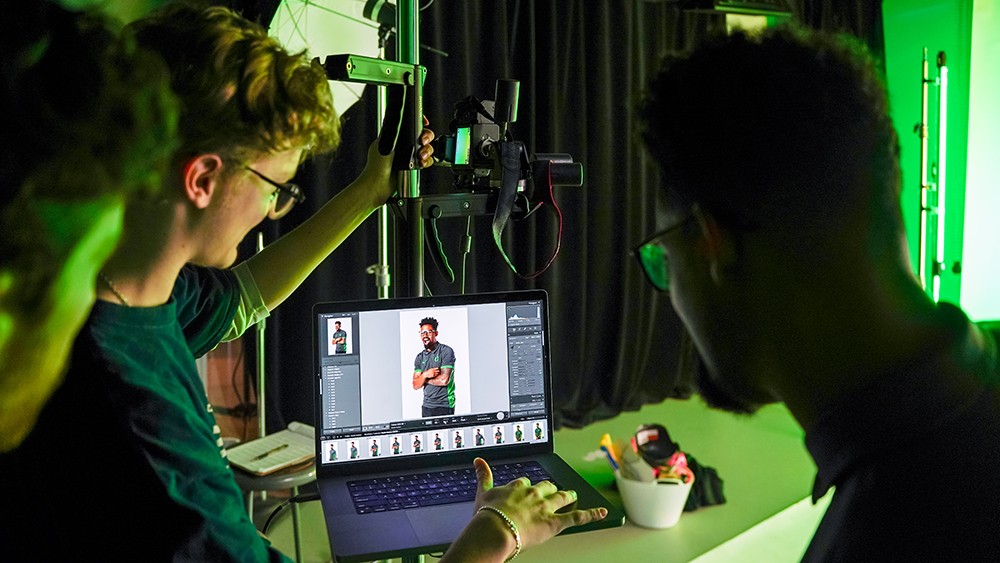 Two students looking at a photo on a computer screen