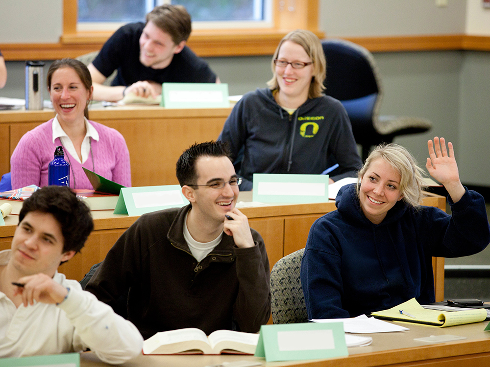 Law student raising their hand in a classroom