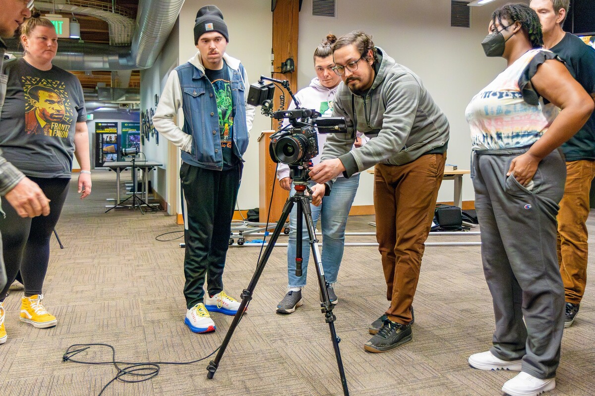 Students gather around a camera during a multimedia production class.