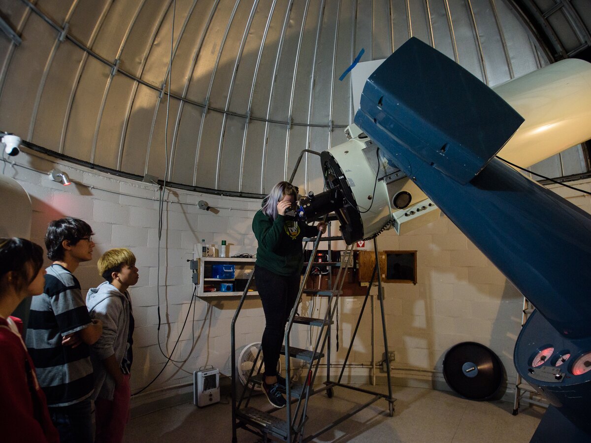 Students use a telescope inside Pine Mountain Observatory.