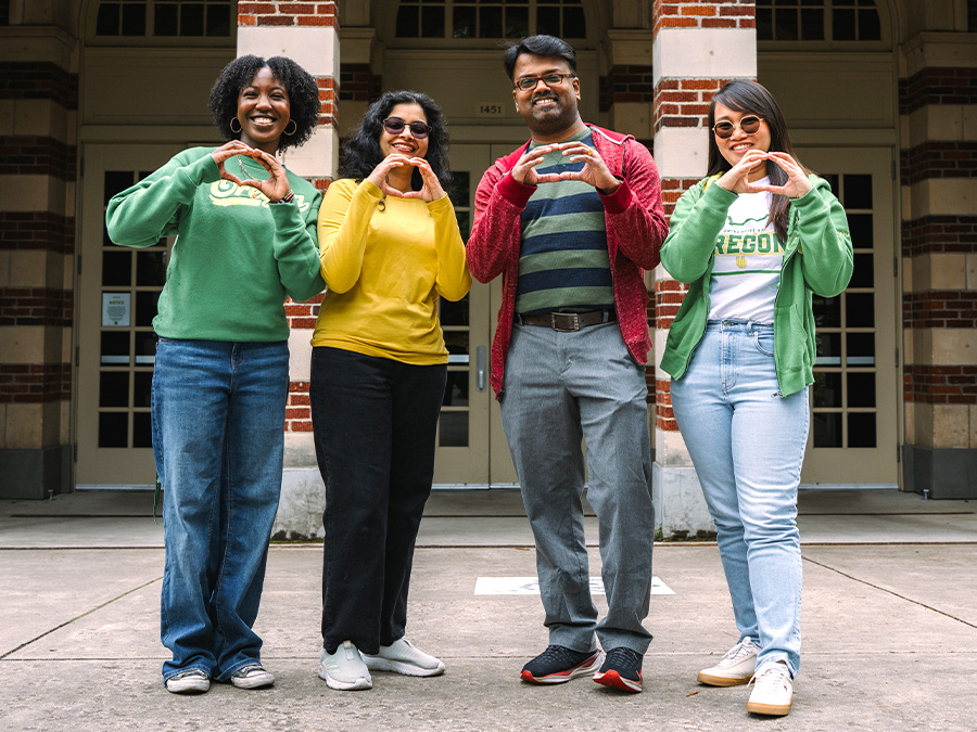 four international students make the "Throw Your O" symbol with their hands