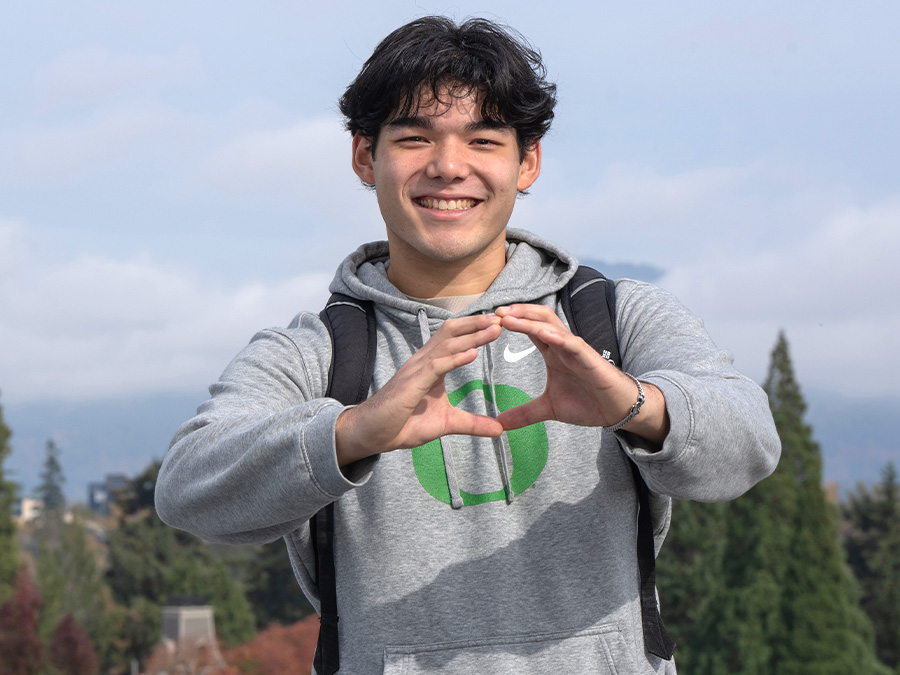 A transfer student makes the "Throw Your O" symbol with his hands.