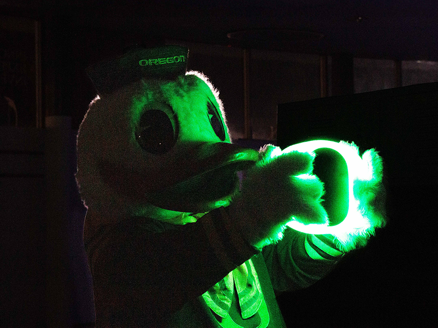 The Duck holding a neon green "O" light