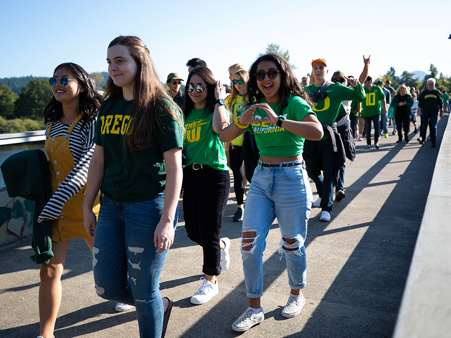 Oregon students and fans walk over the bridge to Autzen Stadium before a game.