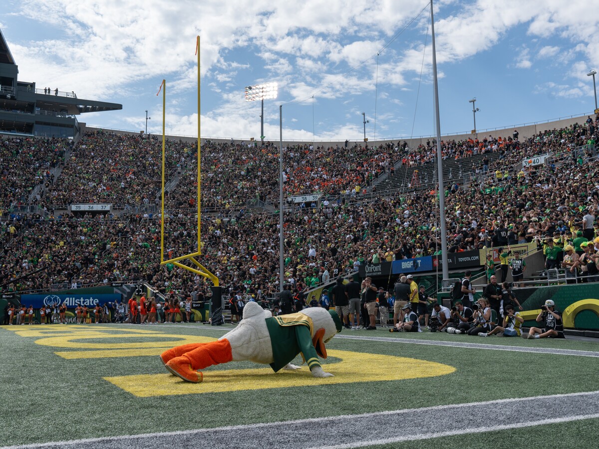 The Oregon Duck performs pushups in an Autzen Stadium end zone.
