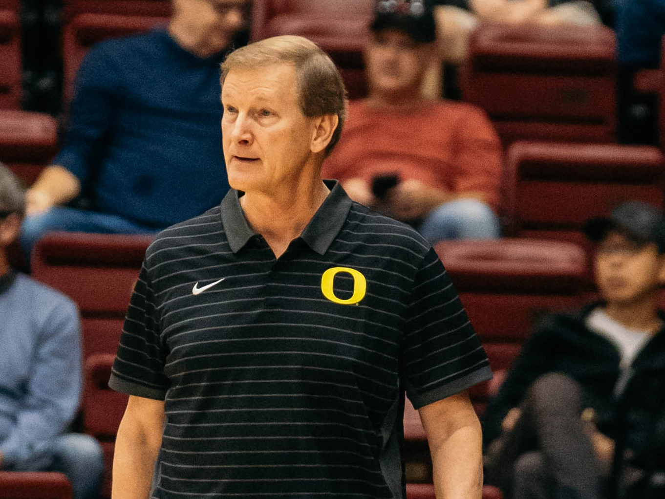 Dana Altman walks along the sideline at a basketball game