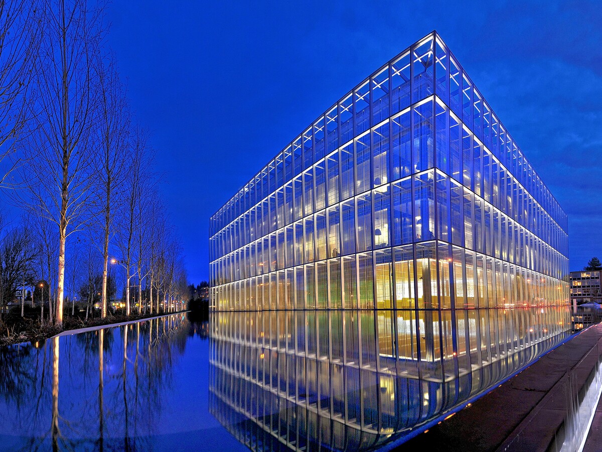 The Jaqua Academic Center glows beside a reflecting pool.