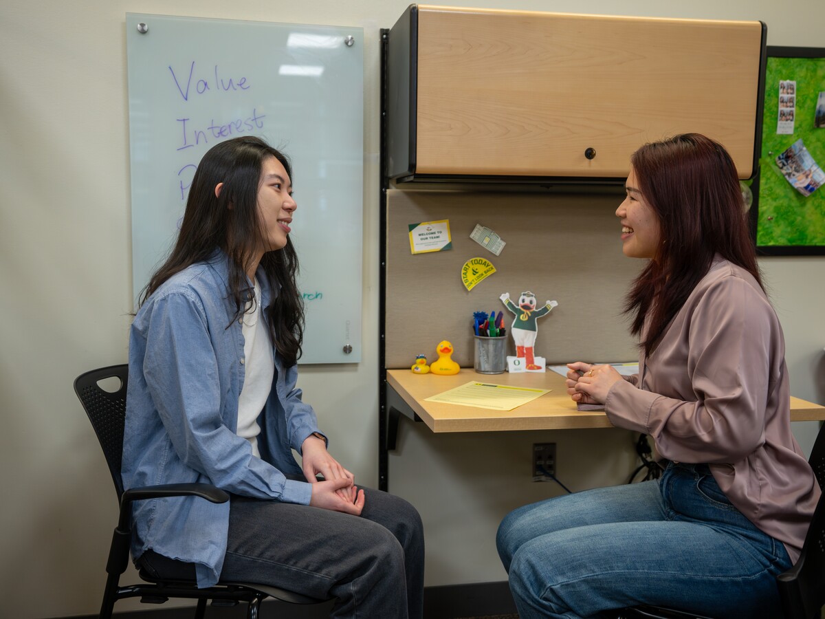 A counselor talks with a student in a comfortable office.