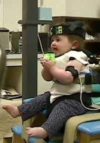 A young child wearing a head and arm monitor in a laboratory