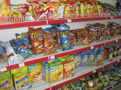 Bags of chips, and boxes of cereals and crackers on store shelves