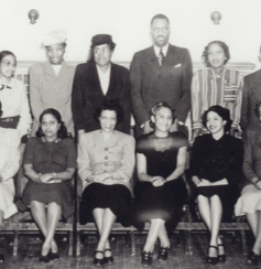 Men and women sitting and standing to pose for a picture