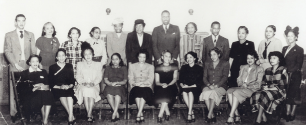 Men and women sitting and standing to pose for a picture