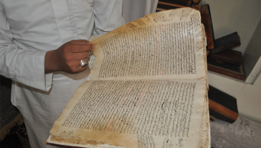 A man turning the pages of an old text