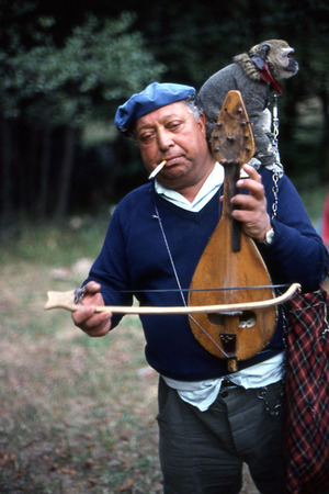 A man playing an instrument with a monkey on his shoulder