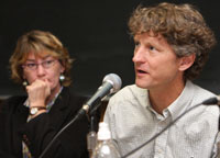 A man and woman speak into microphones