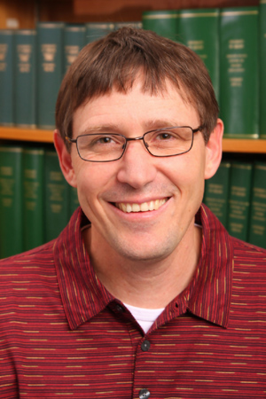 A man in front of a bookcase 