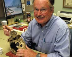 A man working with a human skull at a desk