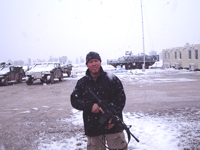 A man holding a gun near tanks